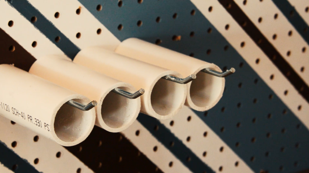 Slide the PVC pipe onto the pegboard hooks and space them out as needed on your pegboard.