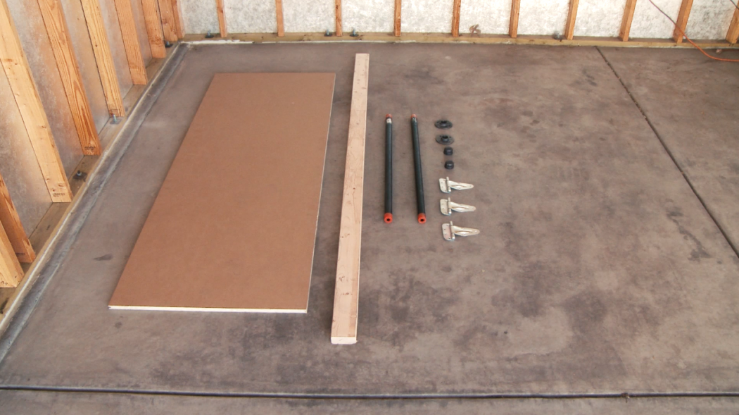 Supplies for the folding workbench laid out on the garage floor