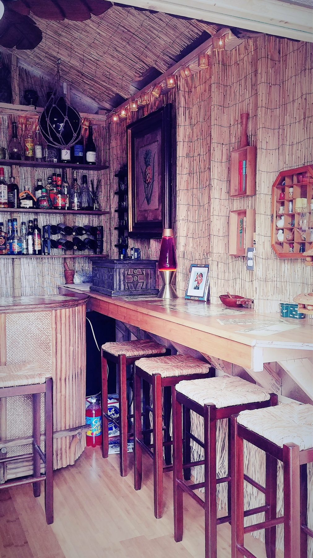 The interior of the Tuff Shed Tiki Shed, featuring bamboo furniture and accents, along with tropical decor.