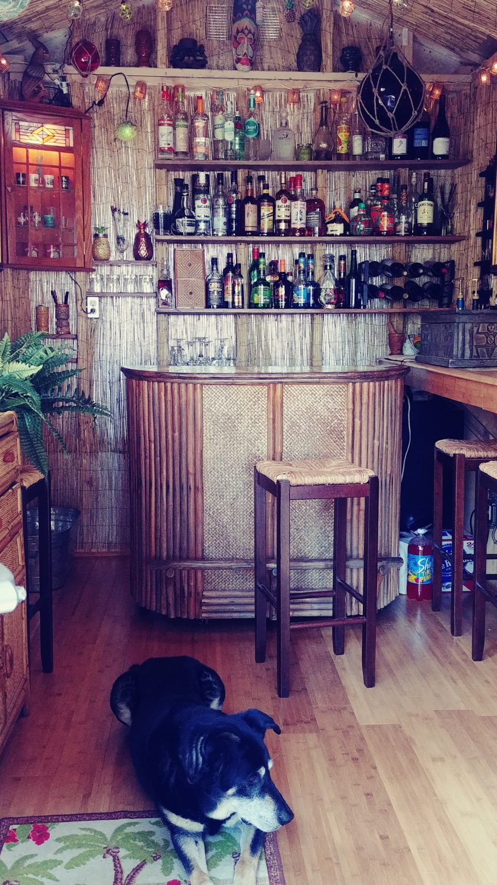 The interior of the Tuff Shed Tiki Shed, featuring bamboo furniture and accents, along with tropical decor.