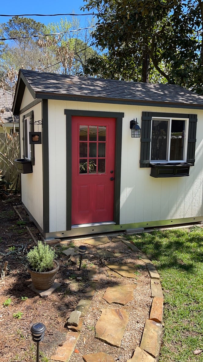 The perfect pub shed, with a bright red door and cozy shutters.