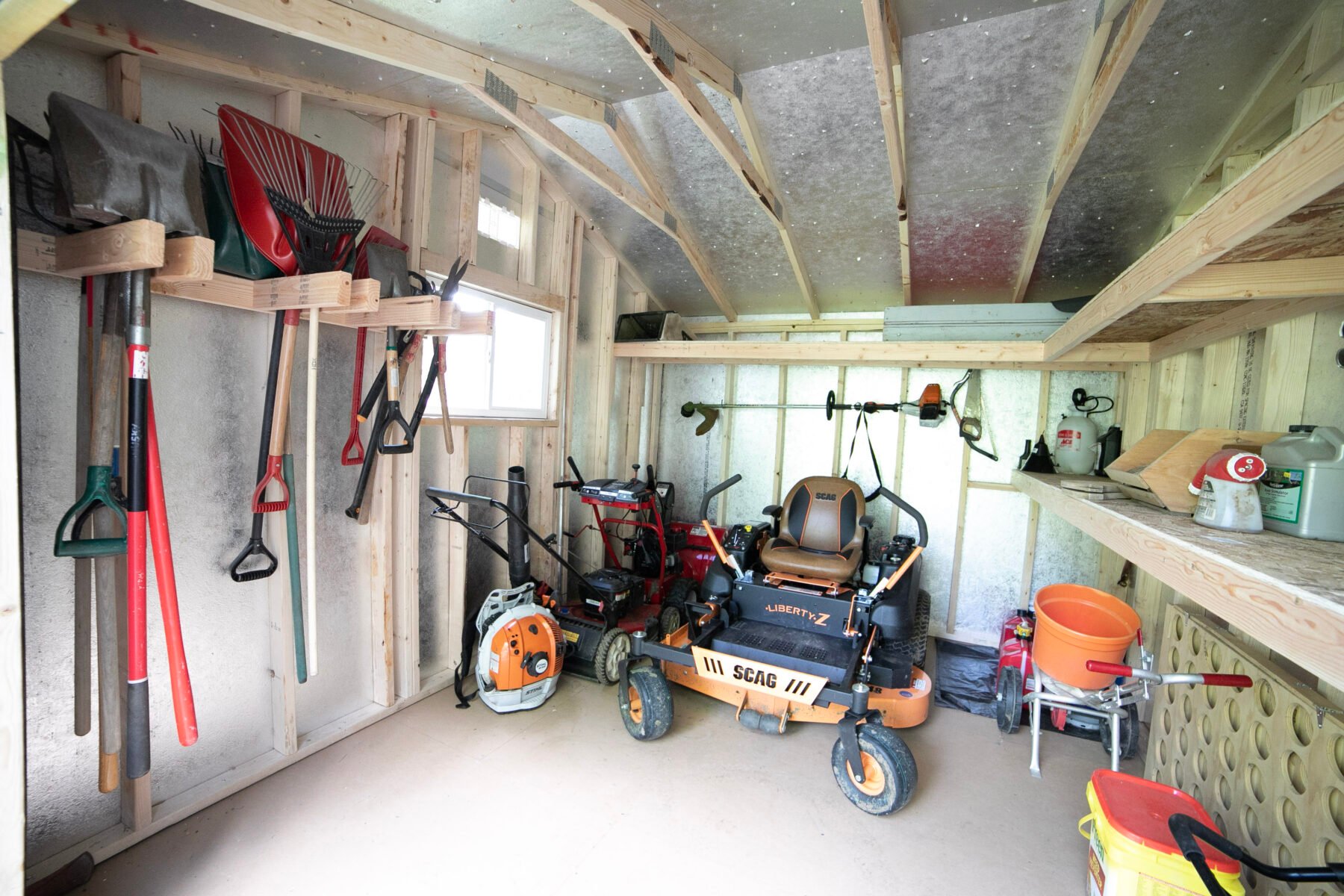 The interior of Noah's garden storage shed. The space keeps all his garden tools organized with custom shelving and racks.