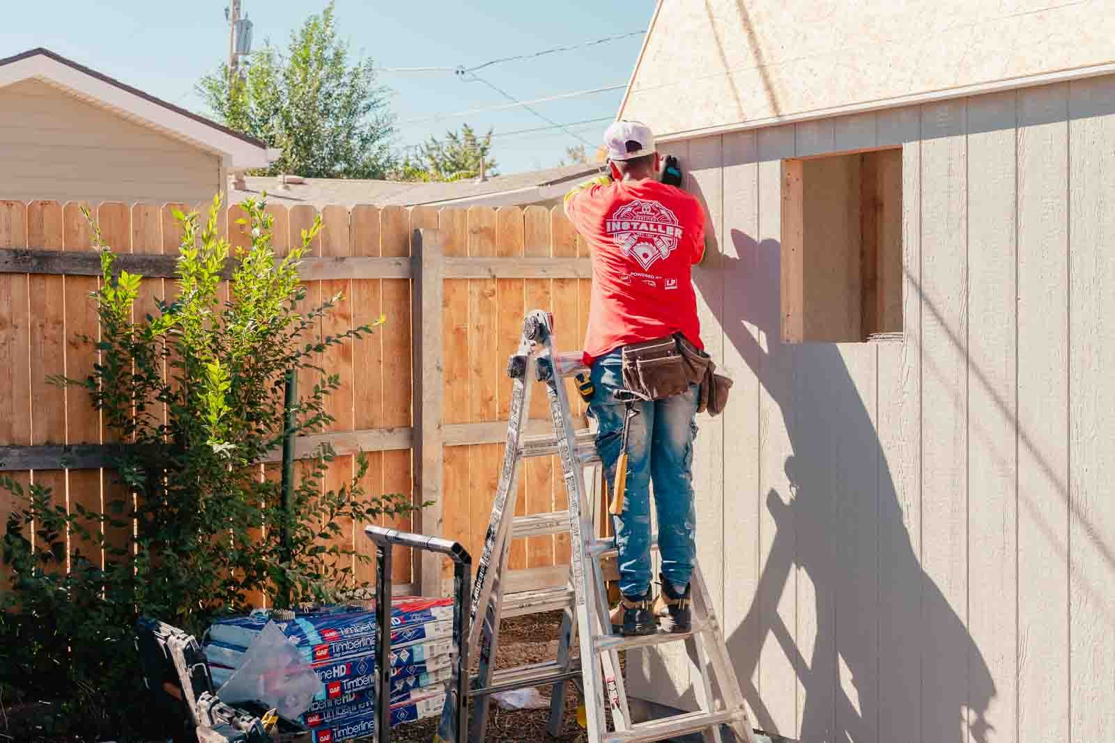 Tuff Shed installer working on the roof of the urban barn