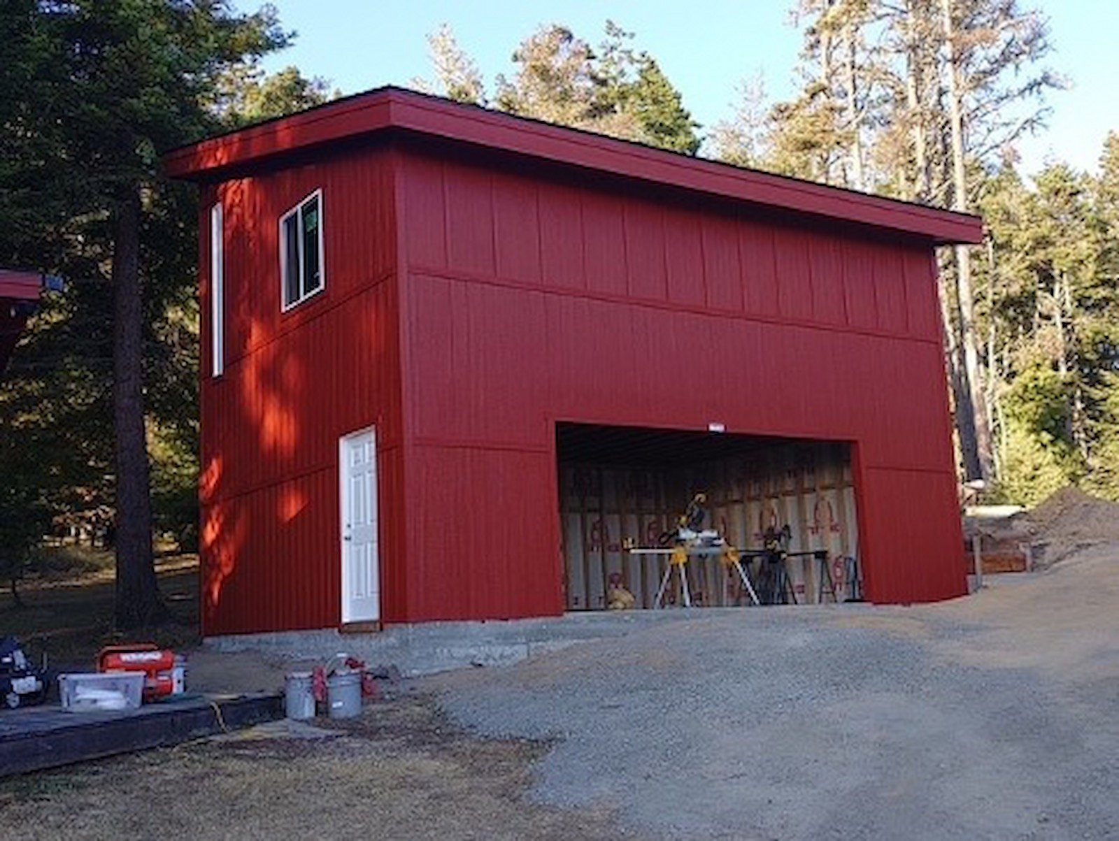 Red two story shed with open garage